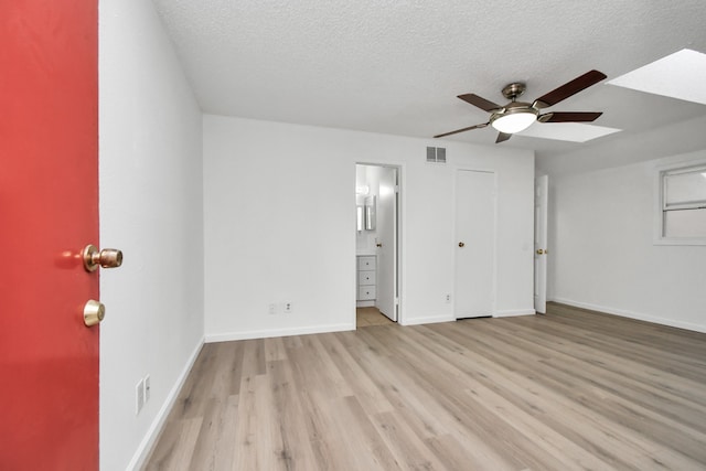 unfurnished bedroom with light hardwood / wood-style flooring, a textured ceiling, and ceiling fan