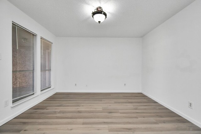 empty room with a textured ceiling and hardwood / wood-style floors