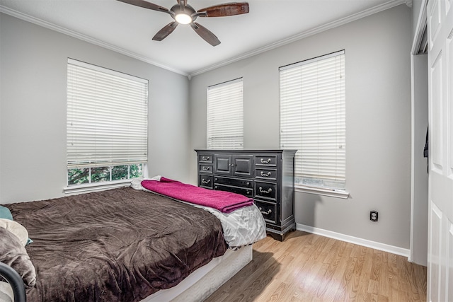 bedroom with light hardwood / wood-style floors, ceiling fan, and crown molding