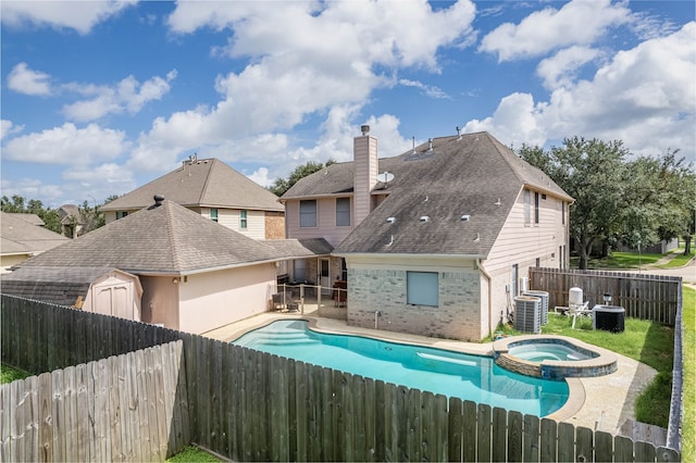 view of swimming pool featuring central air condition unit and an in ground hot tub