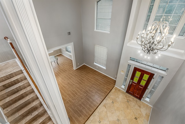 entryway featuring a high ceiling, a notable chandelier, and light hardwood / wood-style flooring