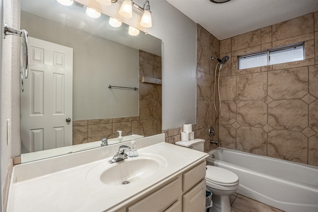 full bathroom with tile patterned floors, toilet, tiled shower / bath, a textured ceiling, and vanity