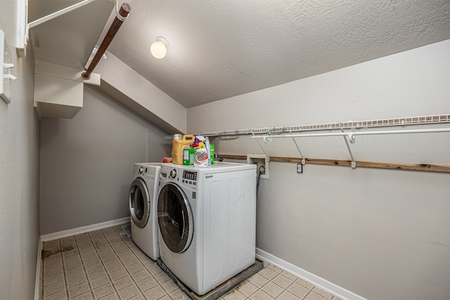 laundry area with separate washer and dryer and a textured ceiling