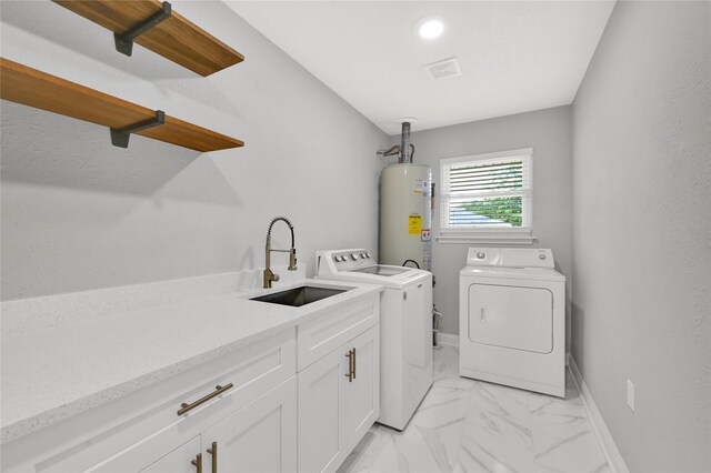 laundry area featuring water heater, cabinets, separate washer and dryer, and sink