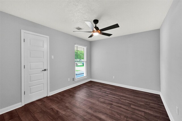 empty room with a textured ceiling, ceiling fan, and dark hardwood / wood-style floors