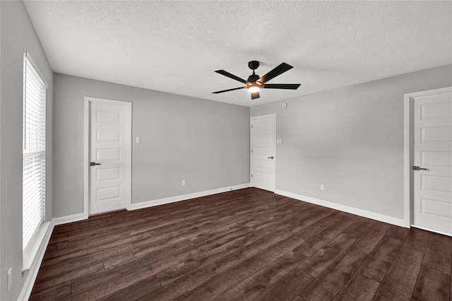 spare room featuring dark hardwood / wood-style flooring, a textured ceiling, and ceiling fan