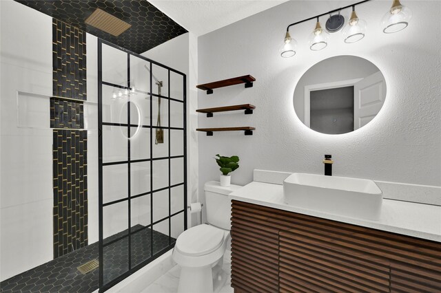 bathroom with tiled shower, vanity, and toilet