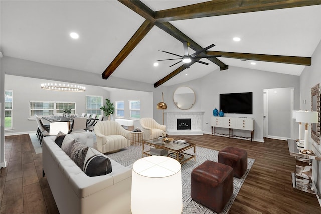 living room with ceiling fan with notable chandelier, lofted ceiling with beams, and dark hardwood / wood-style flooring