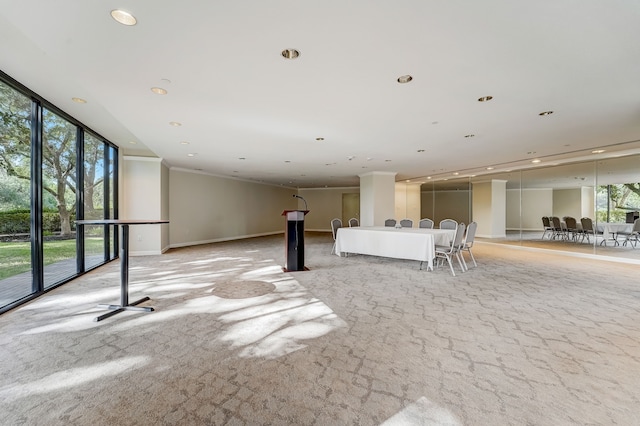 interior space with plenty of natural light, baseboards, a wall of windows, and recessed lighting