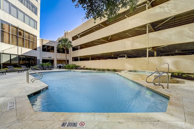 community pool featuring a patio and a hot tub