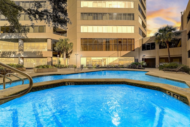 pool at dusk with a community pool