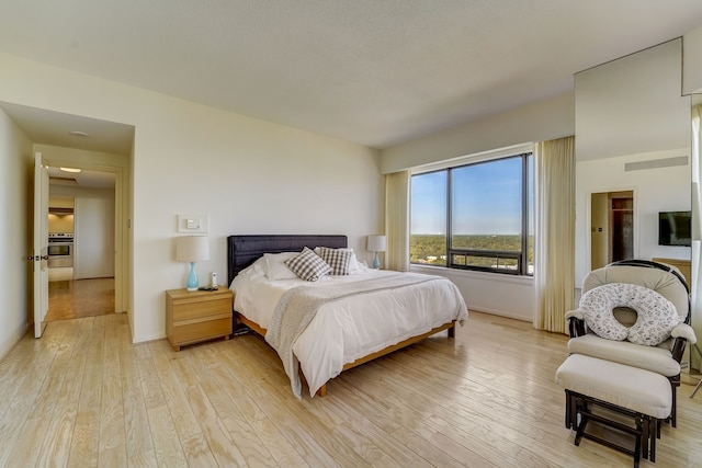 bedroom featuring light wood finished floors and baseboards