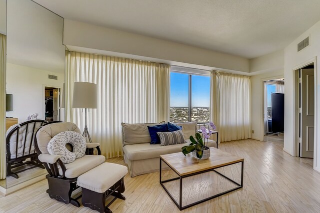 living room featuring visible vents and light wood-style flooring