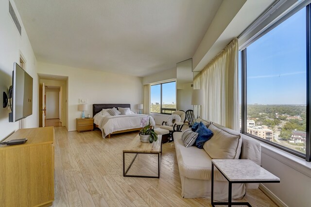 bedroom with visible vents, light wood-style flooring, and baseboards