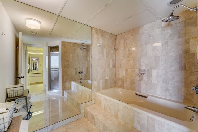 full bath with tile patterned flooring, tiled shower / bath, and tile walls