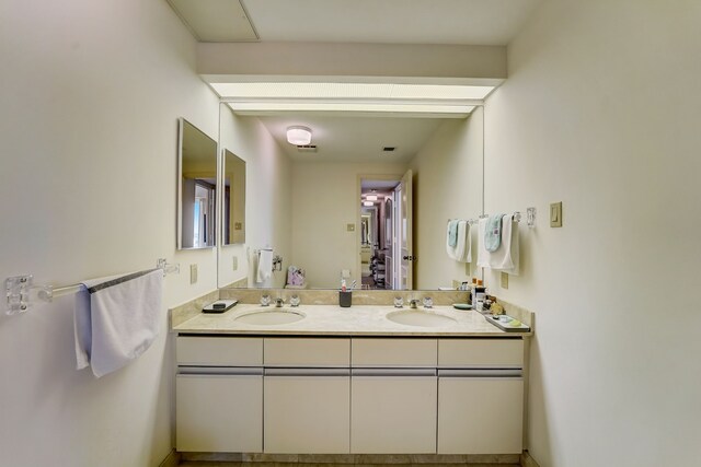 full bathroom with double vanity and a sink