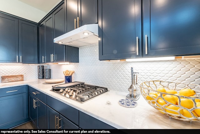 kitchen with stainless steel gas cooktop, blue cabinetry, decorative backsplash, and light stone countertops