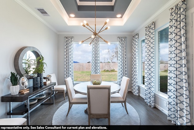 dining room with ornamental molding, a tray ceiling, dark hardwood / wood-style floors, and a chandelier