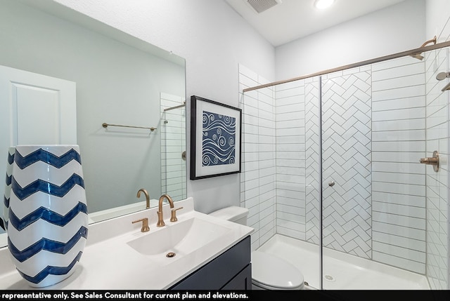 bathroom featuring vanity, tiled shower, and toilet