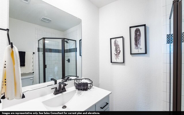 bathroom featuring vanity, walk in shower, and toilet