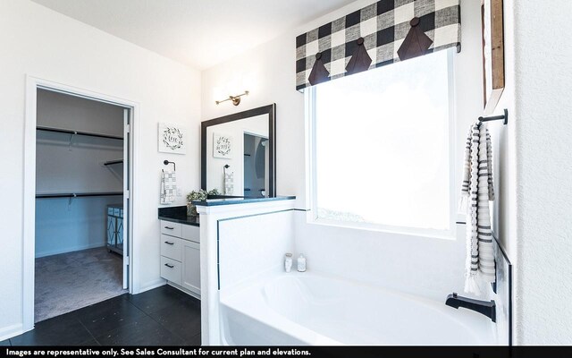 bathroom featuring a washtub, tile patterned floors, and vanity