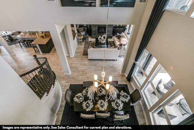 living room featuring a chandelier, tile patterned flooring, and a towering ceiling