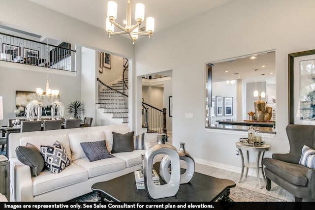 living room with wood-type flooring, a notable chandelier, and a high ceiling