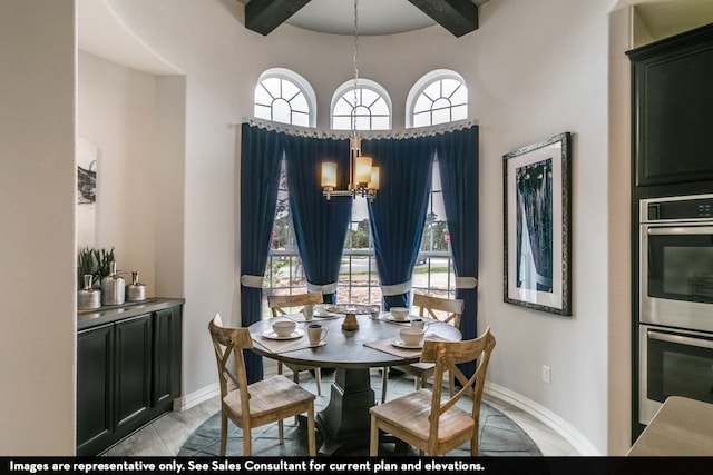 dining space featuring a notable chandelier, beam ceiling, and a towering ceiling