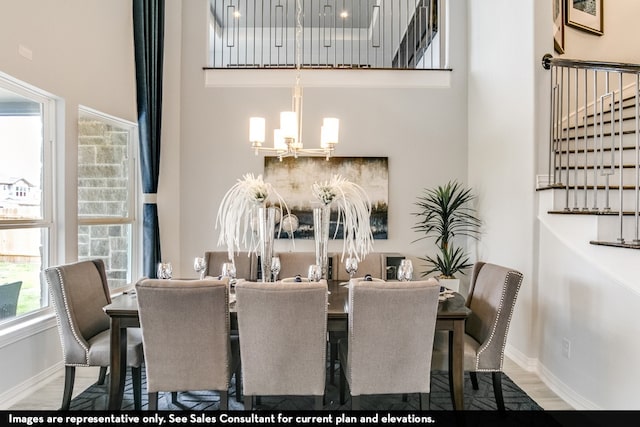 dining space with hardwood / wood-style floors and an inviting chandelier