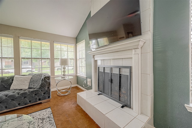 living room featuring lofted ceiling and a tile fireplace