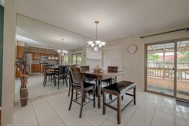 dining space featuring light tile patterned flooring and a chandelier