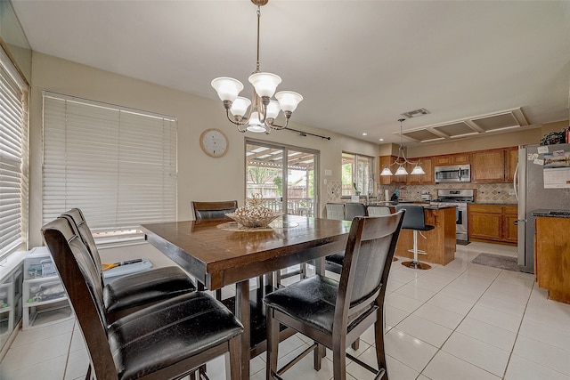 dining area with an inviting chandelier and light tile patterned floors