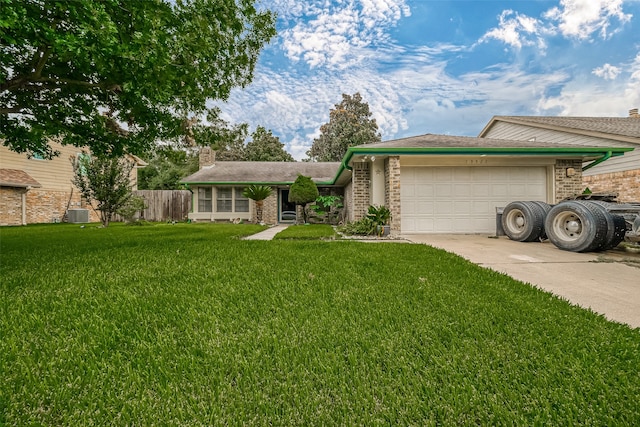 view of front of property featuring cooling unit, a garage, and a front yard