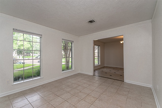 spare room featuring light tile patterned flooring, a wealth of natural light, and a textured ceiling