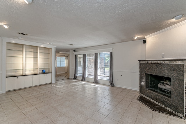 unfurnished living room featuring built in features, a high end fireplace, light tile patterned floors, crown molding, and a textured ceiling