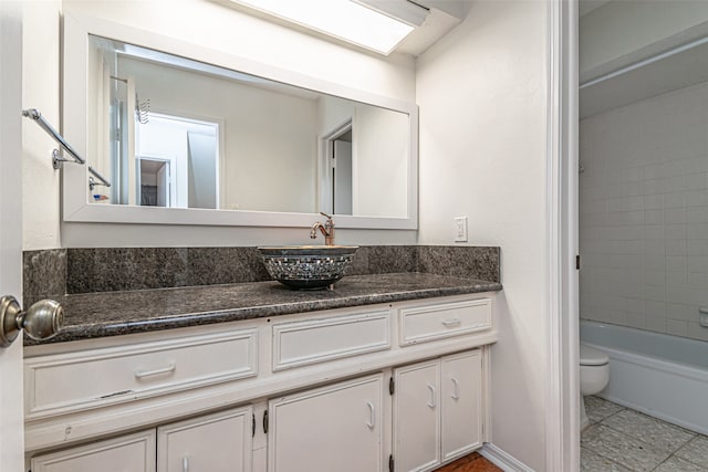 full bathroom featuring vanity, tile patterned flooring, tiled shower / bath combo, and toilet