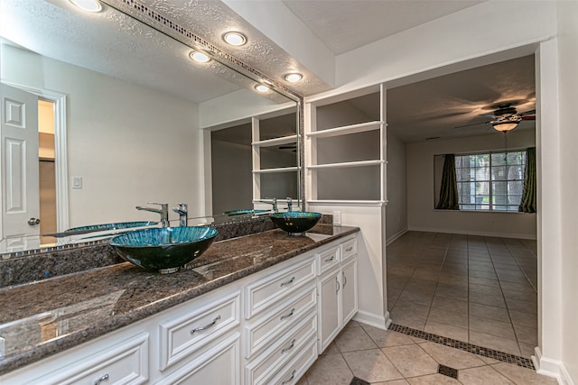 bathroom featuring tile patterned flooring, double vanity, a textured ceiling, and ceiling fan