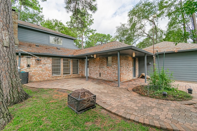 rear view of house with a patio area and an outdoor fire pit