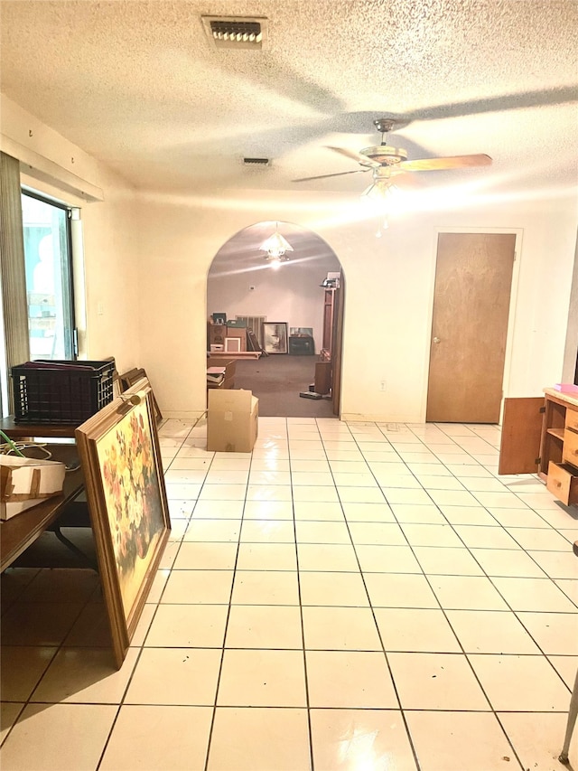 interior space featuring light tile patterned floors and a textured ceiling