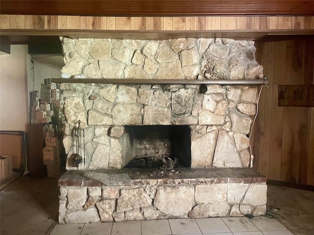 room details with wood ceiling, wooden walls, and a stone fireplace