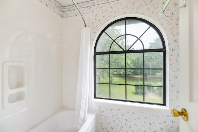 bathroom featuring a healthy amount of sunlight and shower / bath combination with curtain