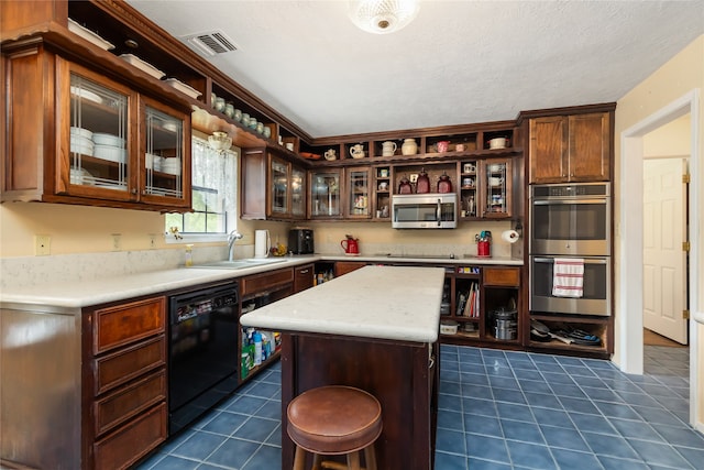 kitchen with a center island, sink, dark tile patterned floors, and black appliances