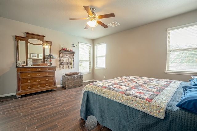 bedroom with dark hardwood / wood-style flooring, ceiling fan, and multiple windows