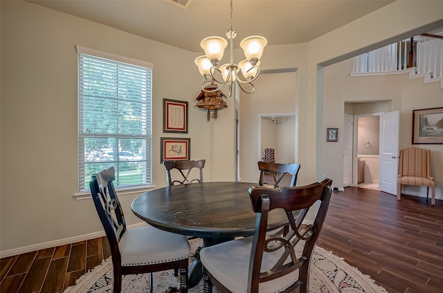 dining room with dark hardwood / wood-style flooring and a chandelier