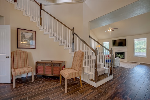 staircase with high vaulted ceiling, wood-type flooring, and ceiling fan