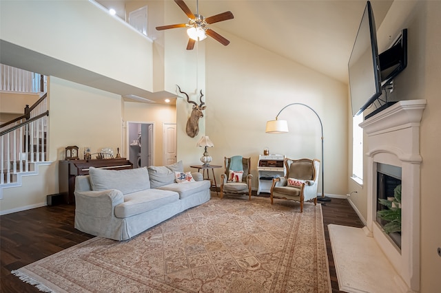 living room featuring dark wood-type flooring, ceiling fan, and high vaulted ceiling