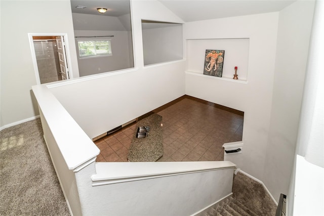 stairs with vaulted ceiling and carpet flooring