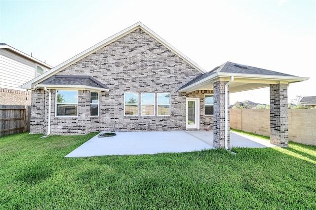 rear view of house with a yard and a patio area