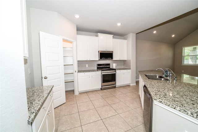 kitchen featuring appliances with stainless steel finishes, sink, white cabinets, and light stone counters