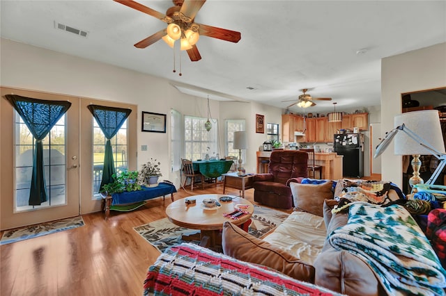 living room with ceiling fan, french doors, and light hardwood / wood-style flooring